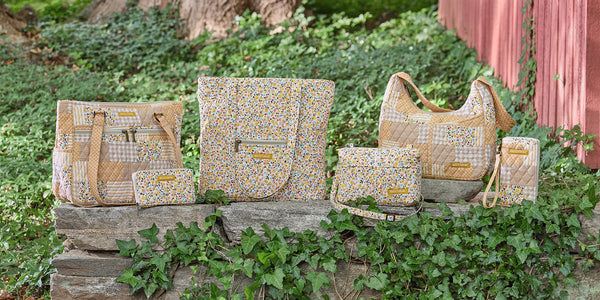 Lifestyle image showcasing Prairie Meadow and Prairie Meadow Patch assortment of bags and accessories arranged together.