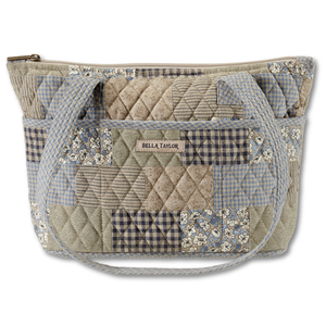 Small Tote front view featuring quilted patchwork print, in dusty blue, navy, & cream, with top zip closure, and 10 total pockets.