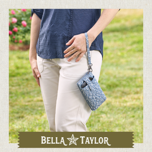 Side-view of woman holding Cell Phone Wristlet made with lightweight 100% cotton.