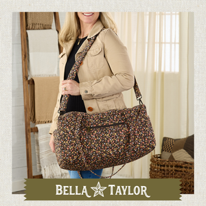 Side-view of woman carrying Navy Floral Duffle highlighting 55" detachable shoulder strap.