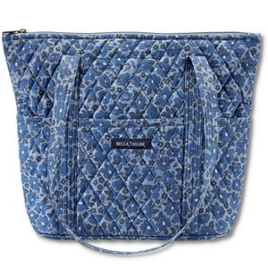 Stride Tote front view featuring quilted floral fabric in dusty blue, cobalt, & navy, with top zip closure, and 10 total pockets.
